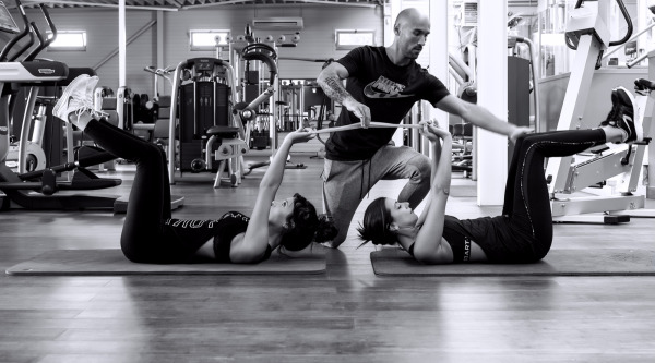 photo of personal trainer Dario Di Lorenzo and two female clients performing a core exercise