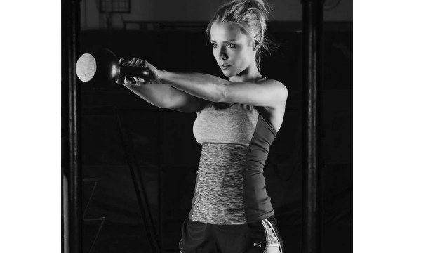 vrouw die zwaait met een kettlebell