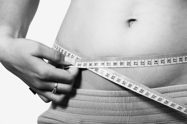 photo of a female measuring het waist circumference